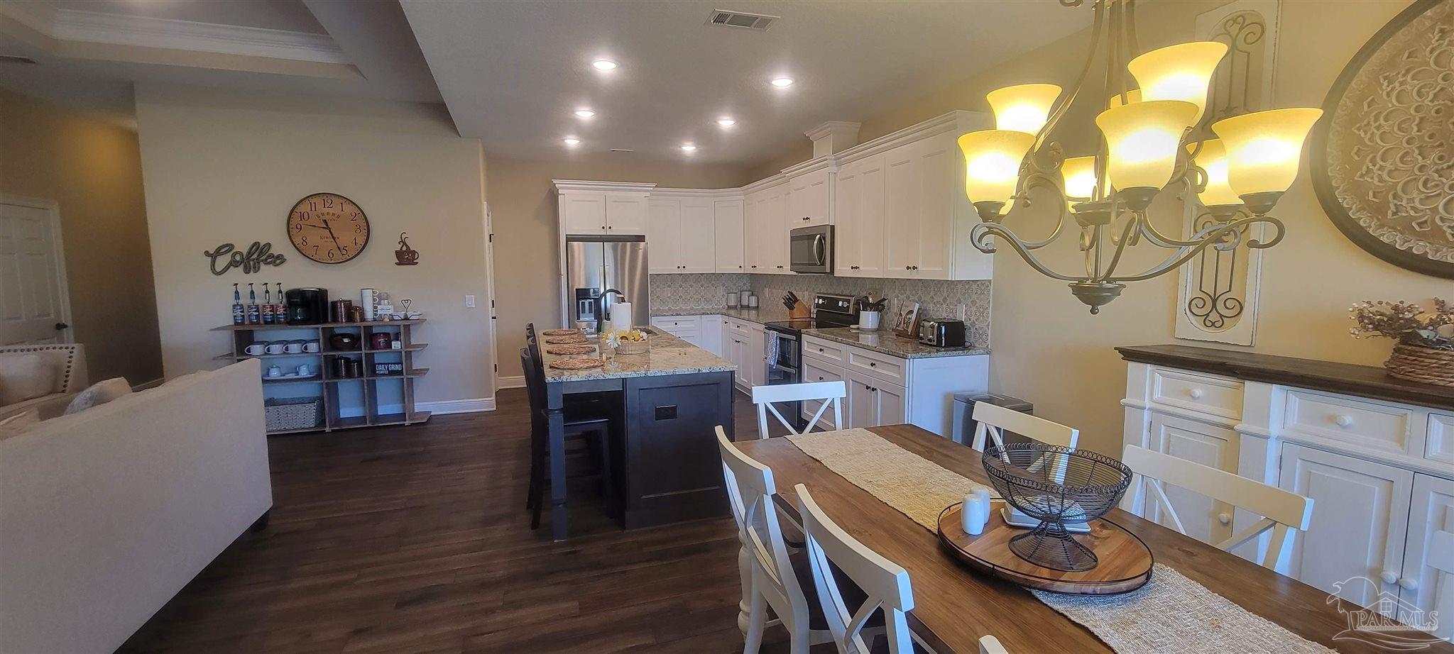 7381 Old Bay Pointe Road Milton, FL 32583 - Photo 3 of 8 a view of a dining room with furniture and wooden floor