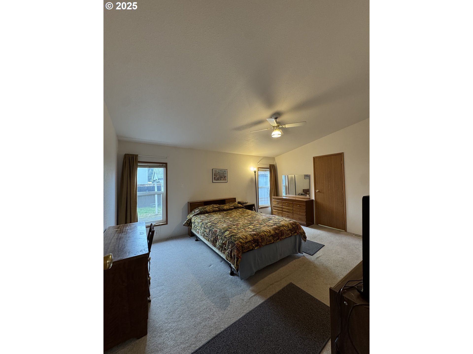 15619 Northeast Caples Road, Unit 72 Brush Prairie, WA 98606 - Photo 18 of 24 a spacious bedroom with a bed and mirror