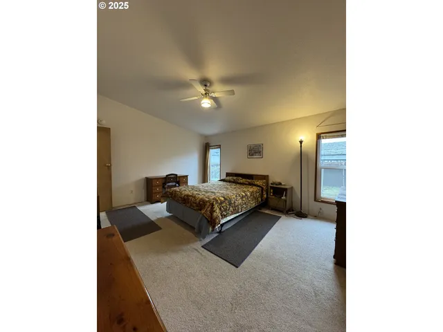 a spacious bedroom with a bed and a chandelier