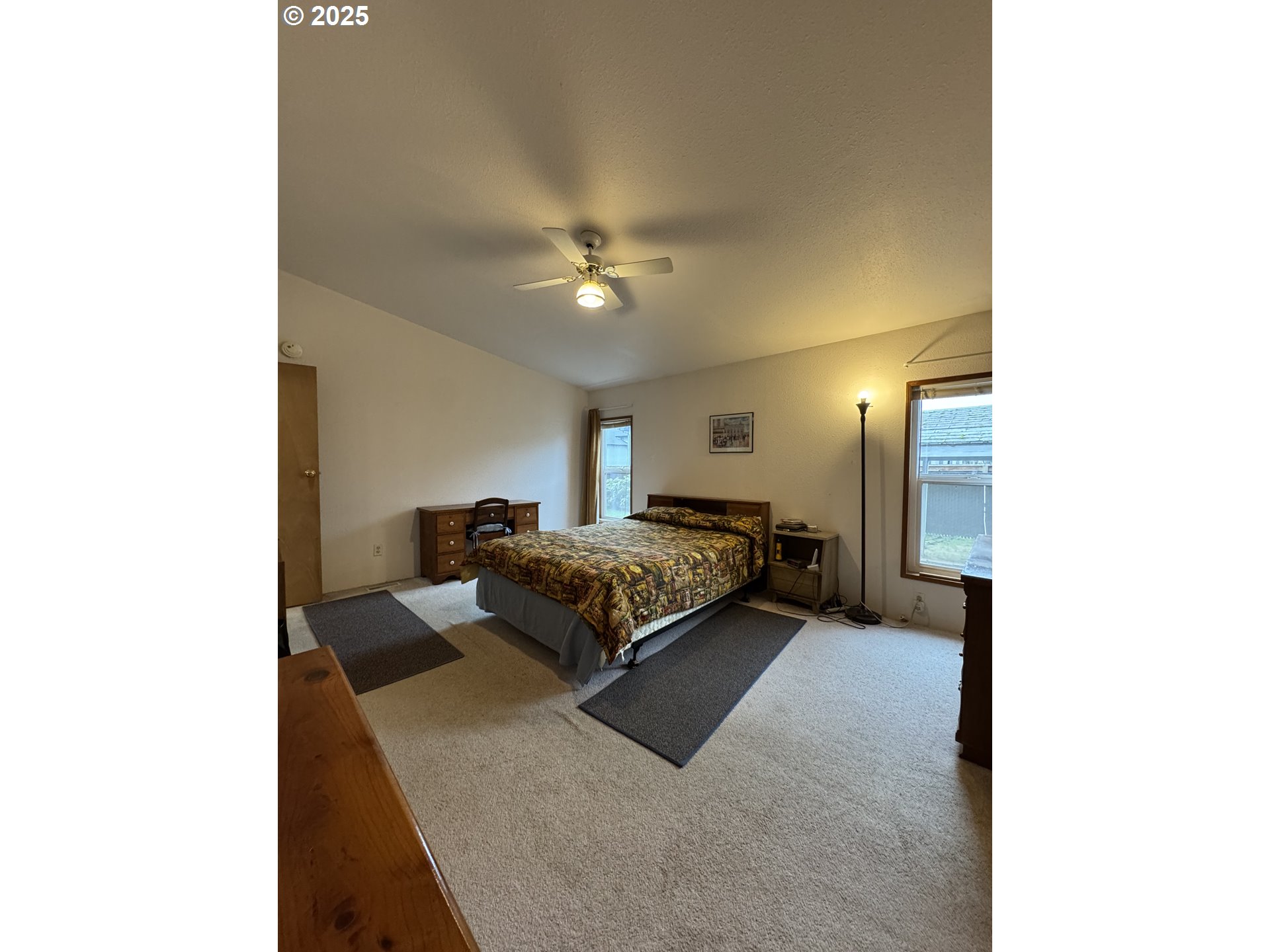 15619 Northeast Caples Road, Unit 72 Brush Prairie, WA 98606 - Photo 19 of 24 a spacious bedroom with a bed and a chandelier