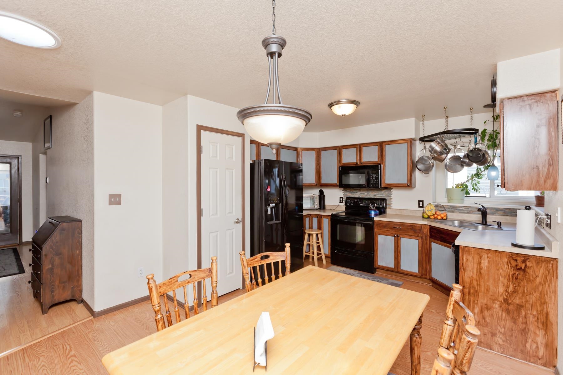 231 Narrow Leaf Drive Fruita, CO 81521 - Photo 20 of 40 a kitchen with stainless steel appliances kitchen island granite countertop a refrigerator a stove a sink a dining table and chairs with wooden floor