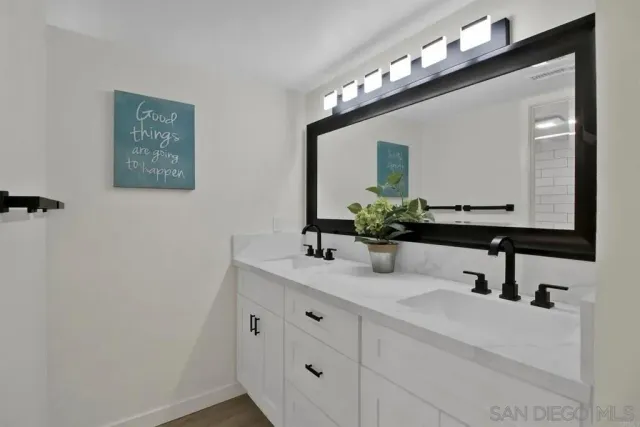a bathroom with a double vanity sink and a mirror