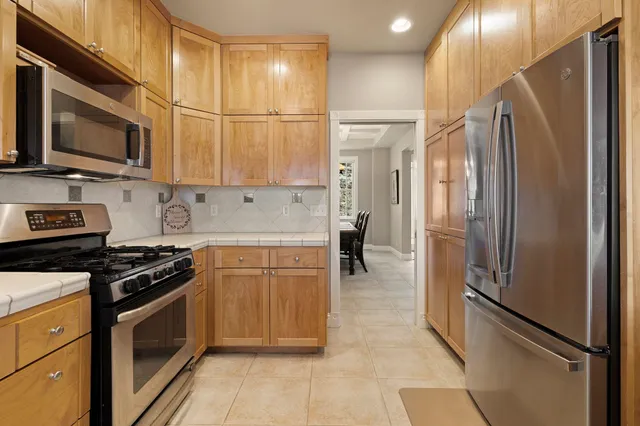 a kitchen with stainless steel appliances granite countertop a stove a sink and a refrigerator