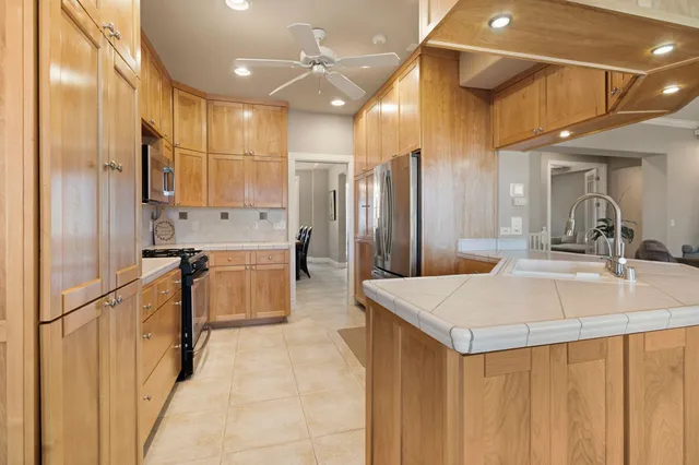a kitchen with stainless steel appliances granite countertop a refrigerator stove and microwave