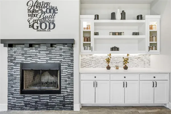a living room with white cabinets and a fireplace