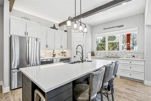 a kitchen with granite countertop a sink appliances cabinets and dining table