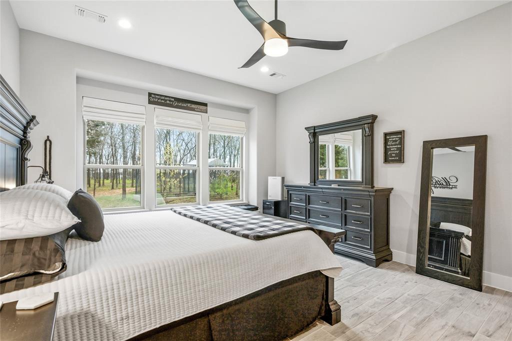 216 Glen Ellen Road Pottsboro, TX 75076 - Photo 22 of 38 a bedroom with a bed dresser and a large window
