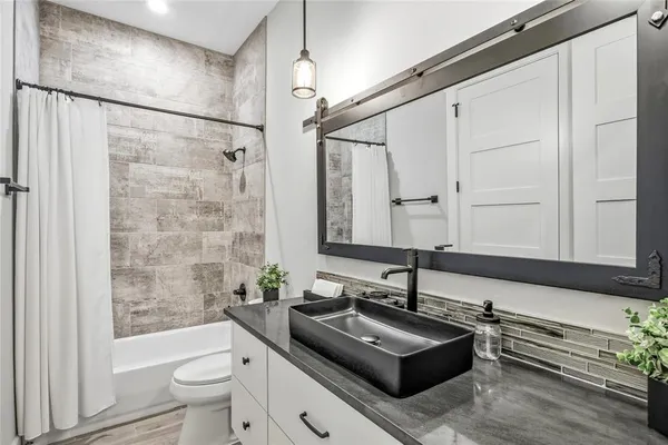 a bathroom with a sink a toilet and shower