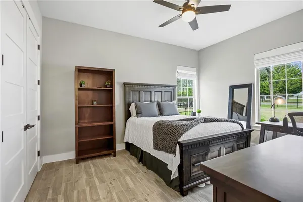 a large bed sitting in a bedroom next to a window and a chandelier