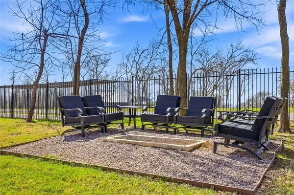 a view of a backyard with chairs potted plants and a bench