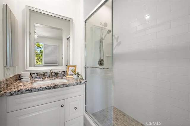 a bathroom with a granite countertop sink mirror and double