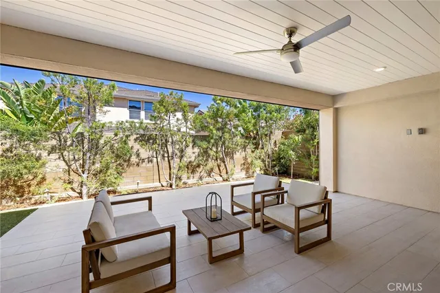 a living room with patio furniture and a grill