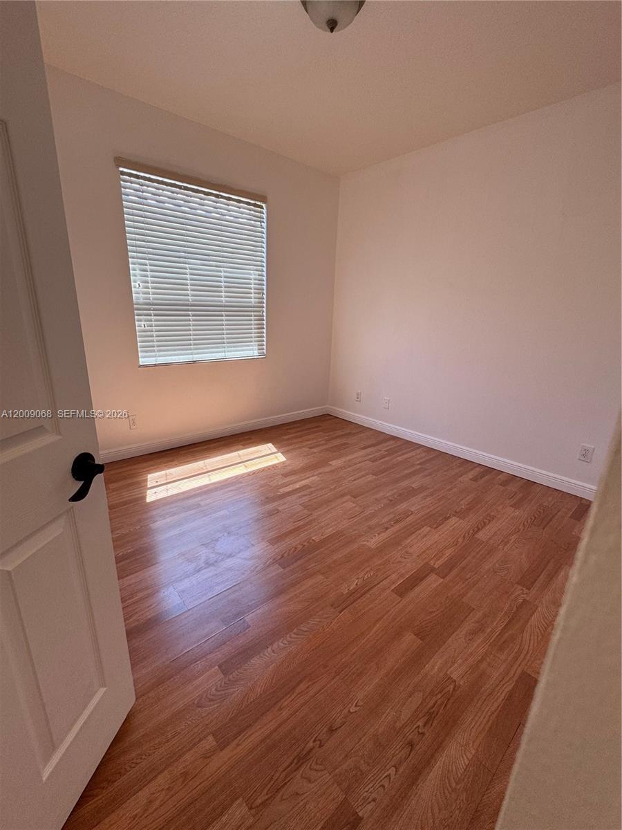 12860 Southwest 51st Street Miramar, FL 33027 - Photo 19 of 29 wooden floor in an empty room with a window