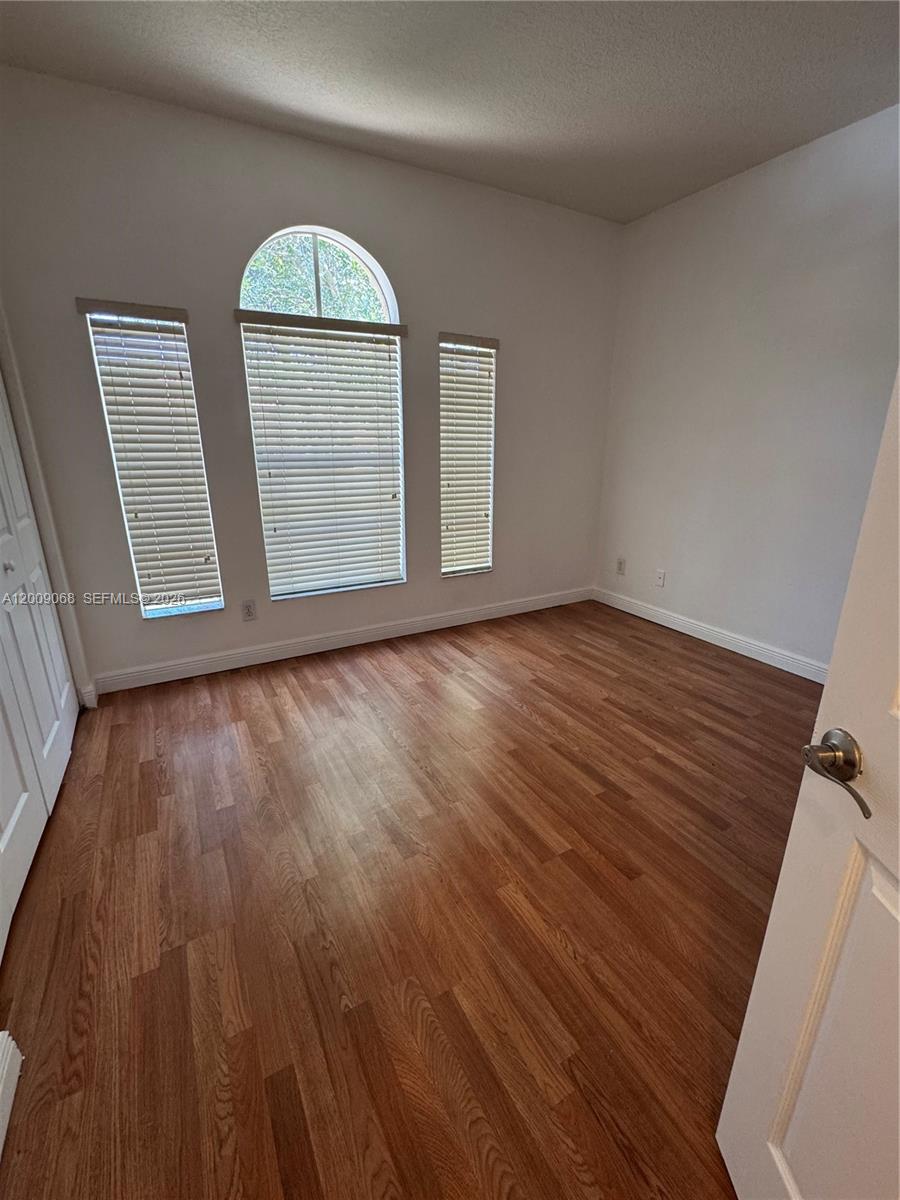 12860 Southwest 51st Street Miramar, FL 33027 - Photo 22 of 29 a view of empty room with wooden floor and fan