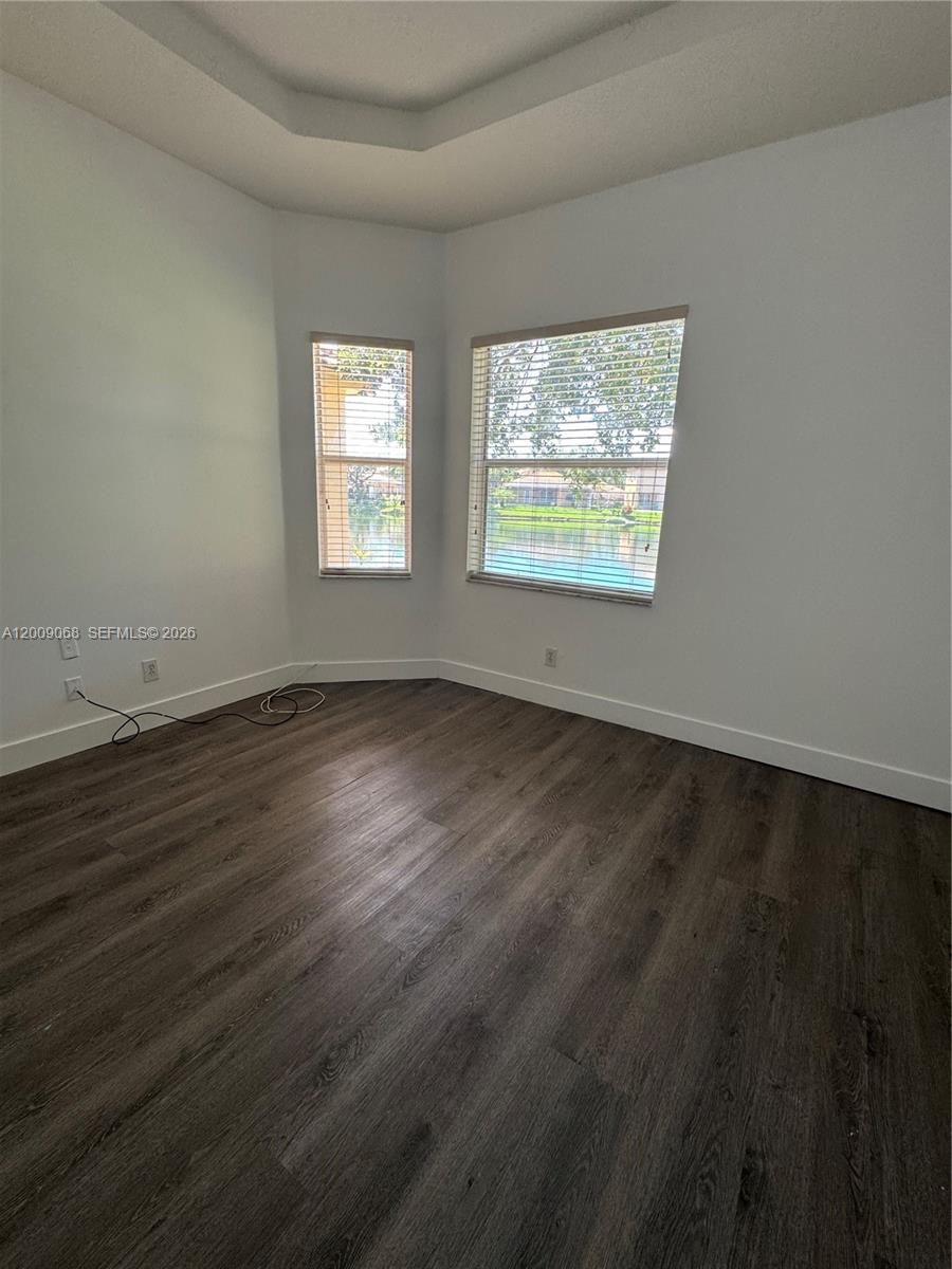 12860 Southwest 51st Street Miramar, FL 33027 - Photo 25 of 29 a view of an empty room with wooden floor and a window