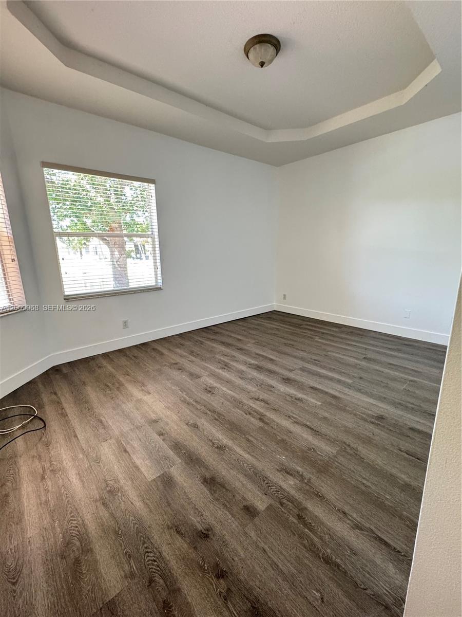 12860 Southwest 51st Street Miramar, FL 33027 - Photo 26 of 29 an empty room with wooden floor and windows