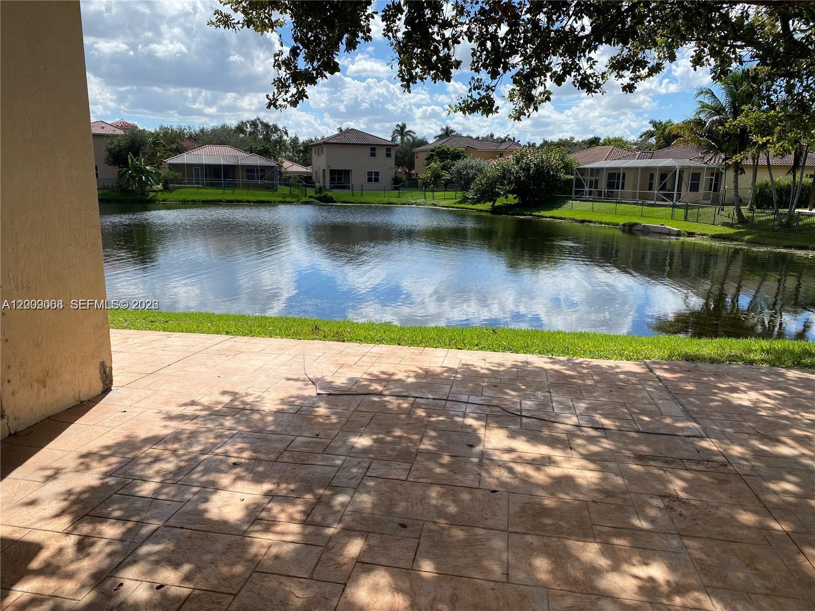 12860 Southwest 51st Street Miramar, FL 33027 - Photo 7 of 29 a view of a lake with houses in the background