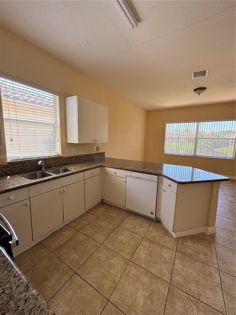 12860 Southwest 51st Street Miramar, FL 33027 - Photo 9 of 29 a kitchen with a sink cabinets and window