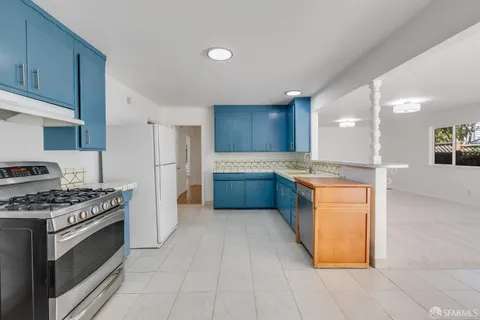 a kitchen with stainless steel appliances granite countertop a stove a sink and a refrigerator