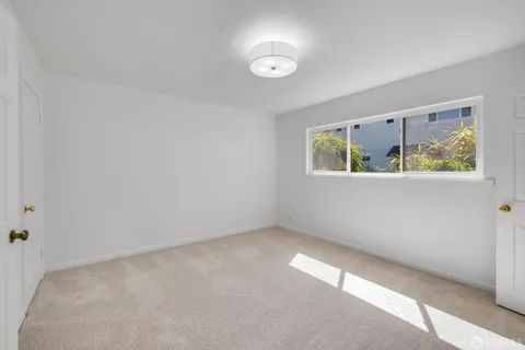 an empty room with windows and closet