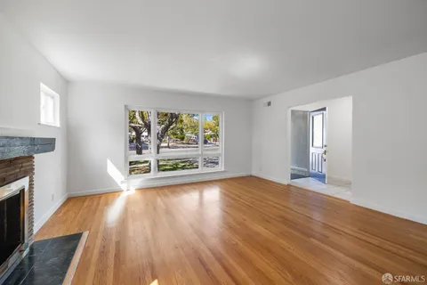 wooden floor fireplace and windows in an empty room