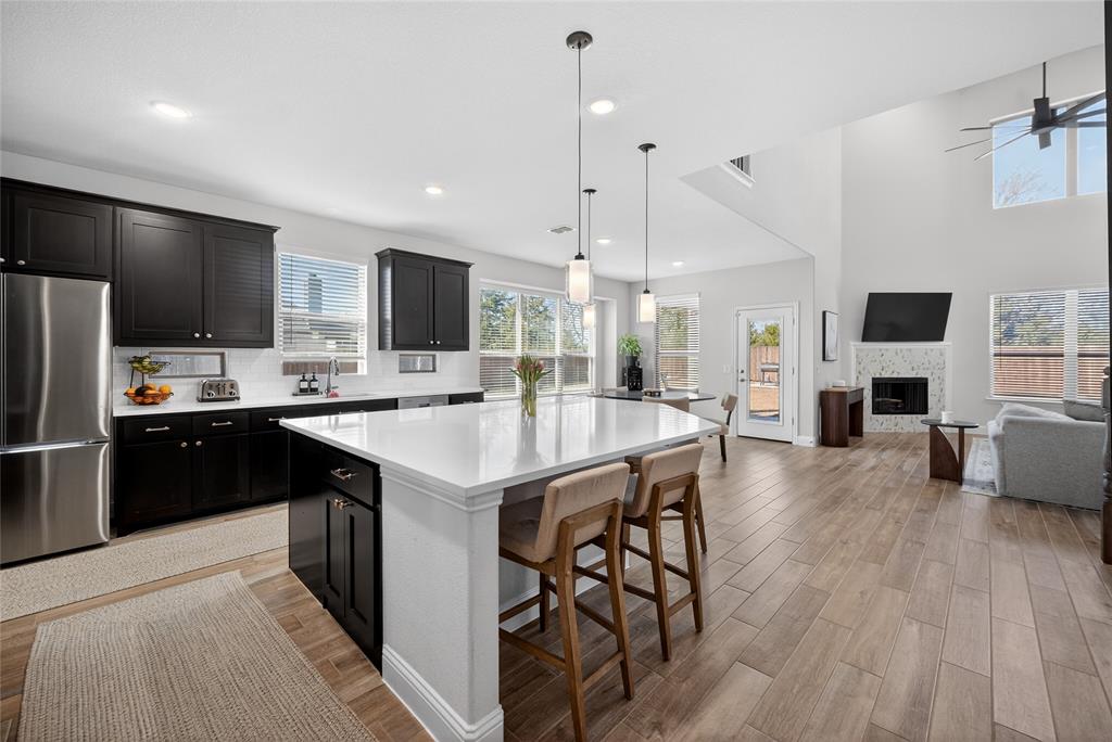 596 Randys Way Pilot Point, TX 76258 - Photo 40 of 40 a kitchen with stainless steel appliances kitchen island granite countertop a sink refrigerator and cabinets