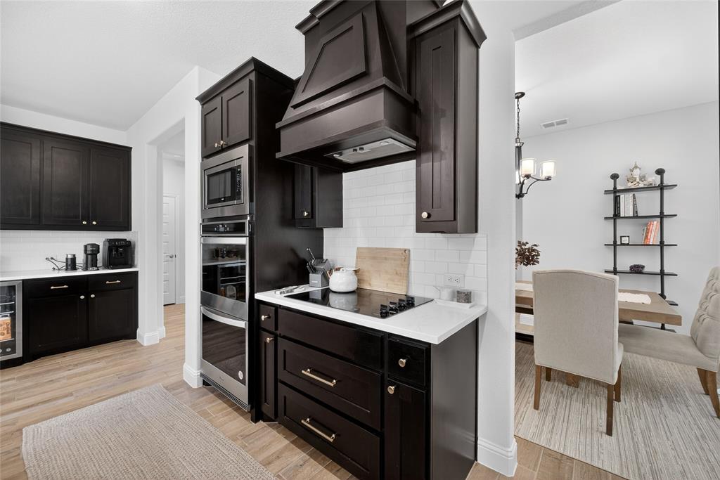 596 Randys Way Pilot Point, TX 76258 - Photo 15 of 40 a kitchen with stainless steel appliances kitchen island granite countertop a sink cabinets and wooden floor