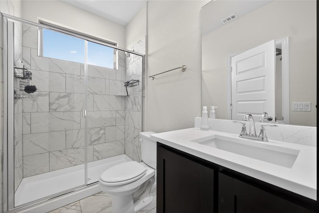 596 Randys Way Pilot Point, TX 76258 - Photo 33 of 40 a bathroom with a sink a toilet and shower
