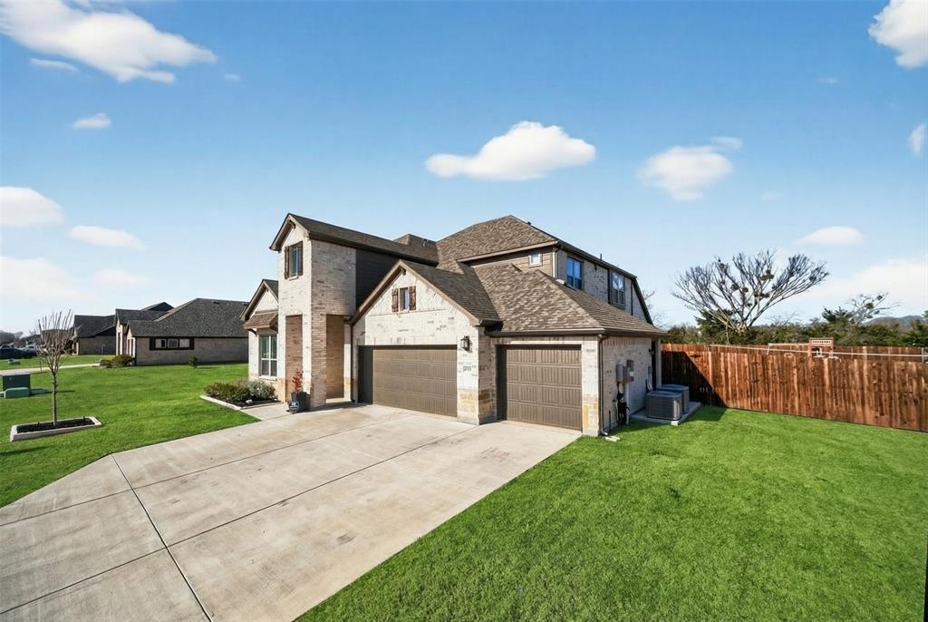 596 Randys Way Pilot Point, TX 76258 - Photo 4 of 40 a front view of a house with a yard and garage