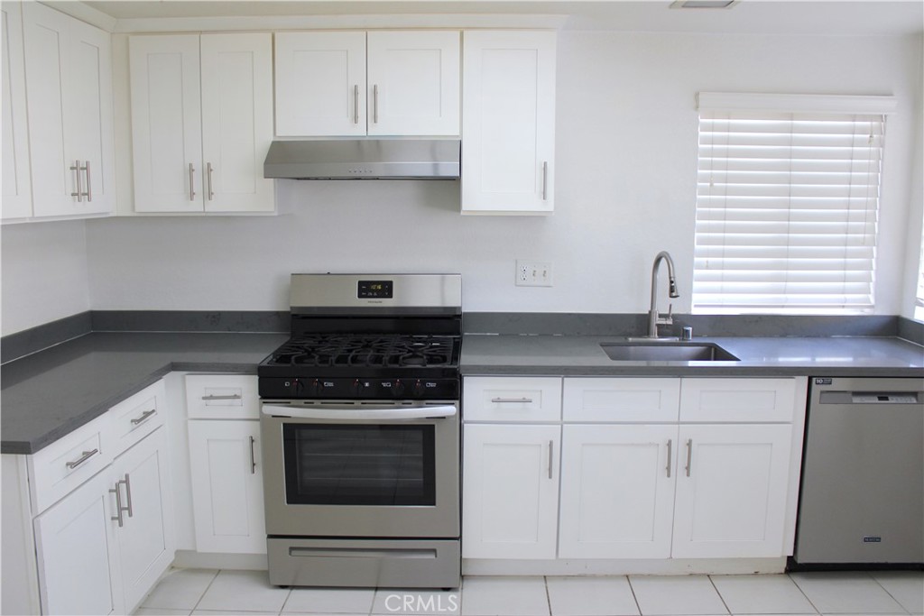 45 Bridgeport Irvine, CA 92620 - Photo 6 of 20 a kitchen with white cabinets and appliances