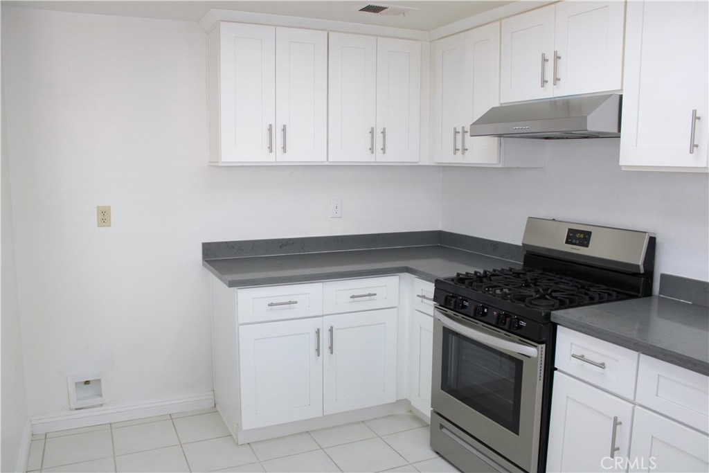 45 Bridgeport Irvine, CA 92620 - Photo 7 of 20 a kitchen with white cabinets and appliances