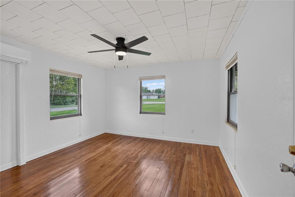 5514 Southeast Hames Road Belleview, FL 34420 - Photo 11 of 44 a view of empty room with wooden floor and fan