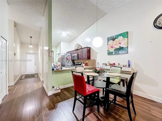 a view of a dining room with furniture a rug and wooden floor