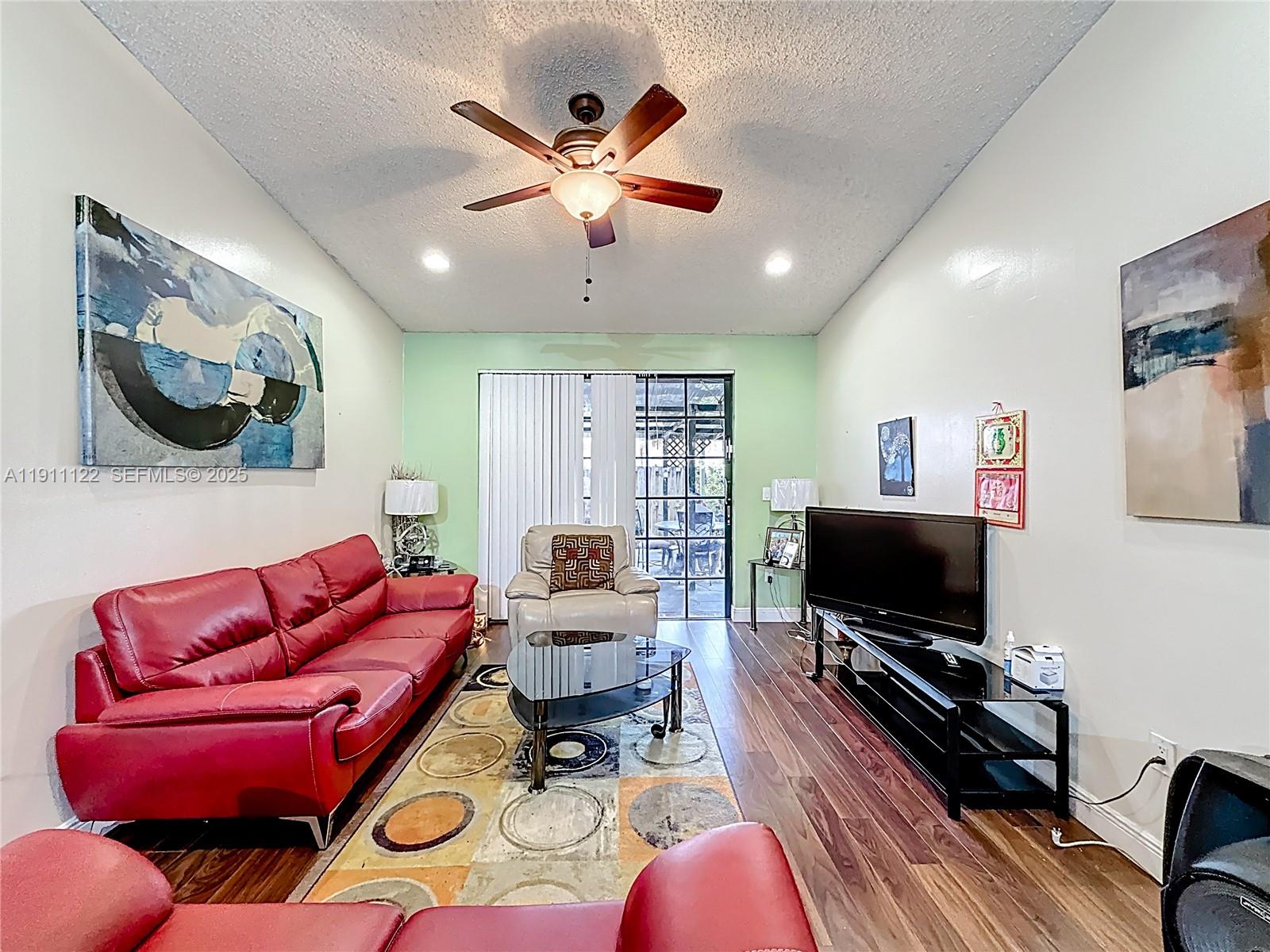 6722 Northwest 192nd Lane Hialeah, FL 33015 - Photo 18 of 46 a living room with furniture a flat screen tv and kitchen view