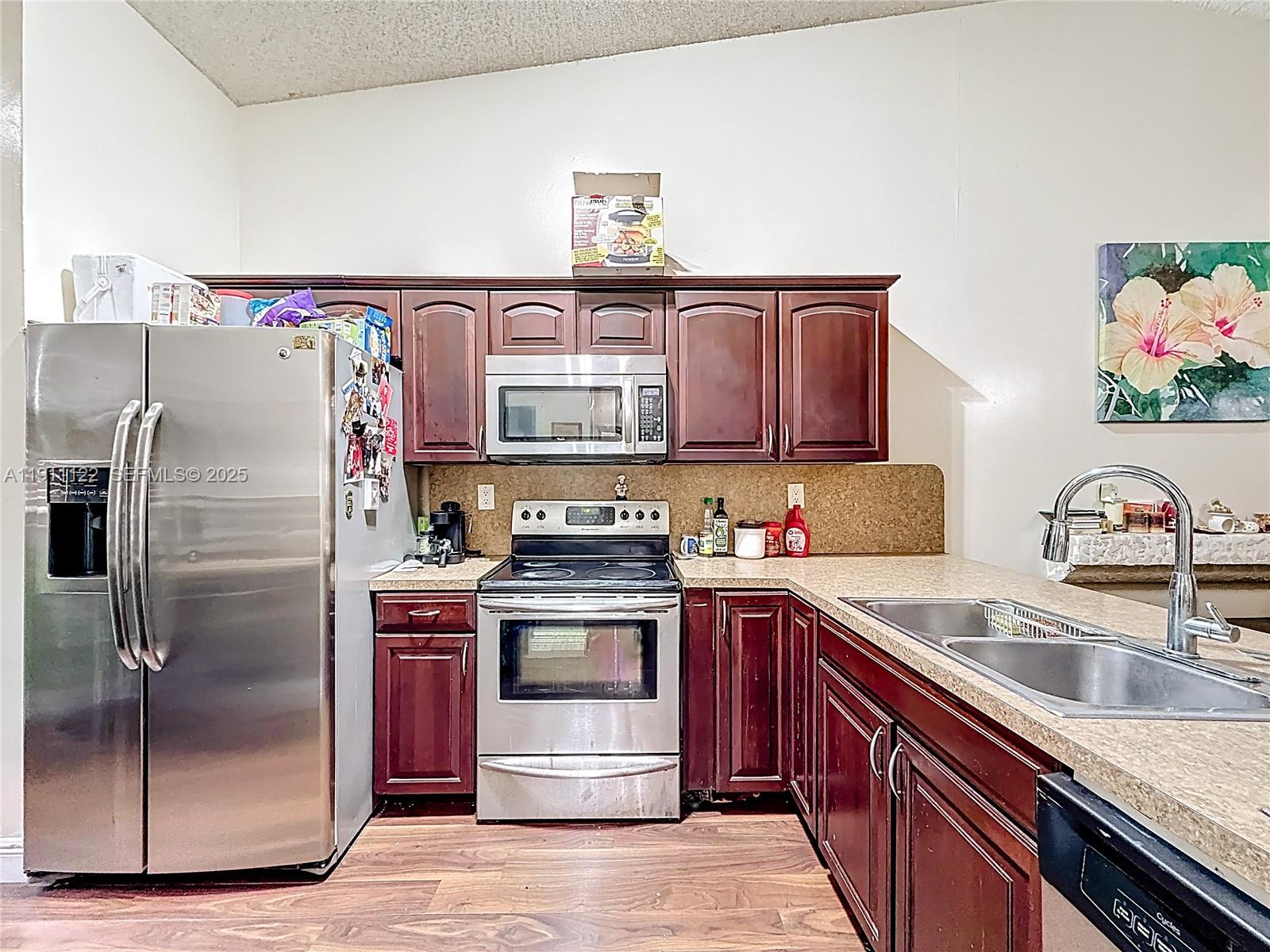 6722 Northwest 192nd Lane Hialeah, FL 33015 - Photo 2 of 46 a kitchen with stainless steel appliances granite countertop a sink stove and refrigerator