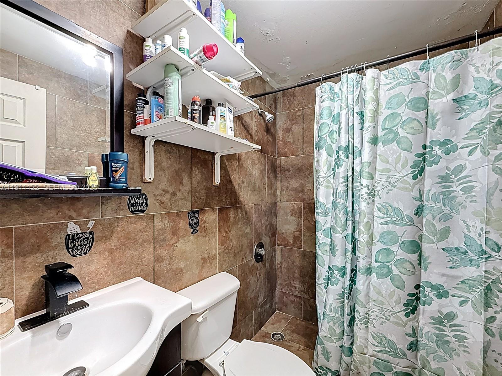 6722 Northwest 192nd Lane Hialeah, FL 33015 - Photo 31 of 46 a bathroom with a sink and mirror with toilet