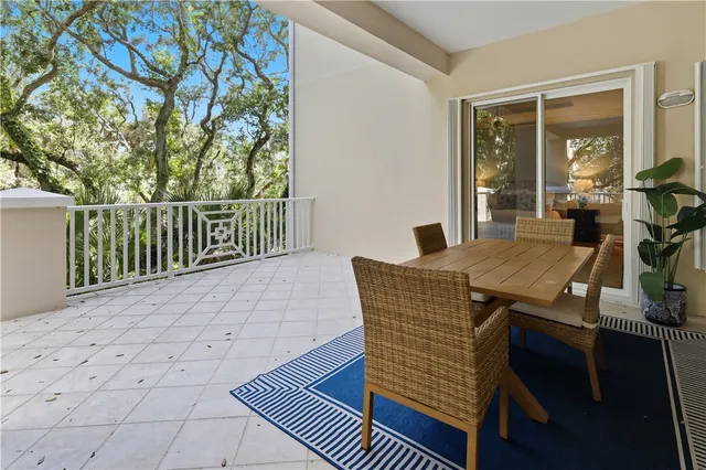 a view of a patio with table and chairs with wooden floor and fence