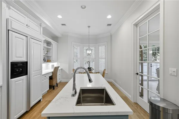 a kitchen with stainless steel appliances granite countertop a sink dishwasher a stove and a refrigerator with wooden floor