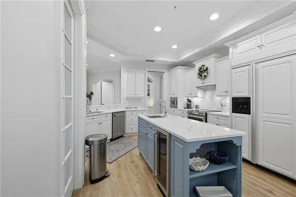 a kitchen with white cabinets and refrigerator
