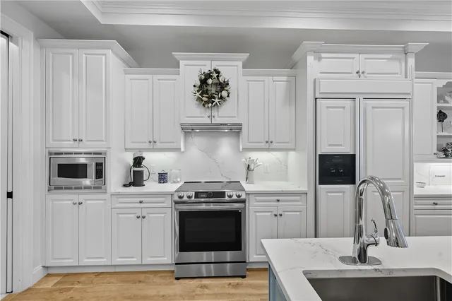 a kitchen with white cabinets and appliances