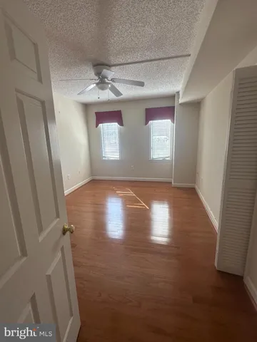 en empty room with windows and ceiling fan