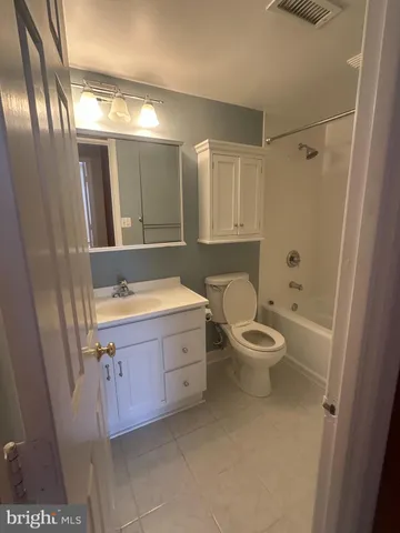 a bathroom with a granite countertop toilet a sink and a mirror