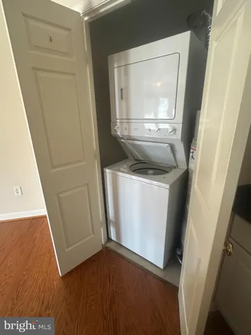 a utility room with wooden floor washer and dryer