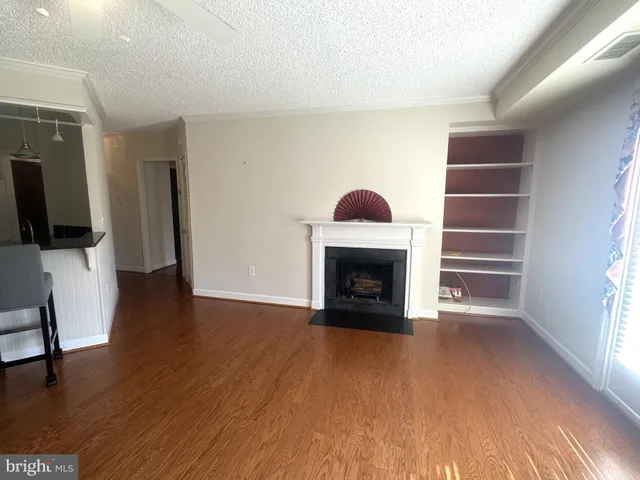 a view of an empty room with a fireplace and a window