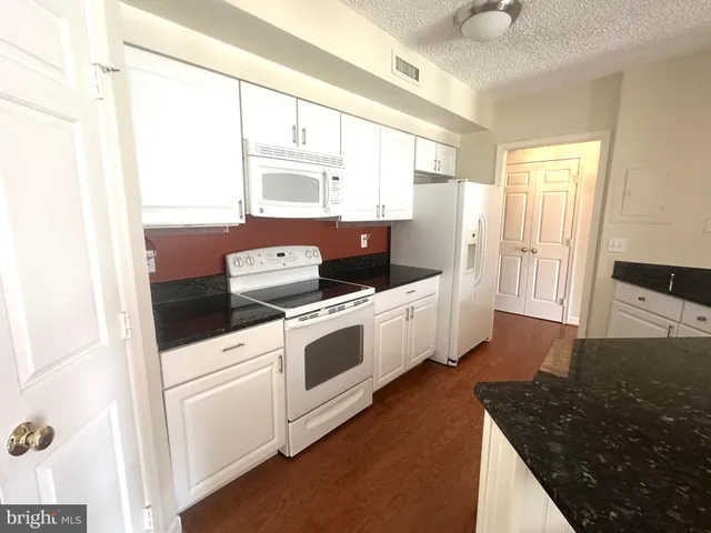 a kitchen with a stove and white cabinets