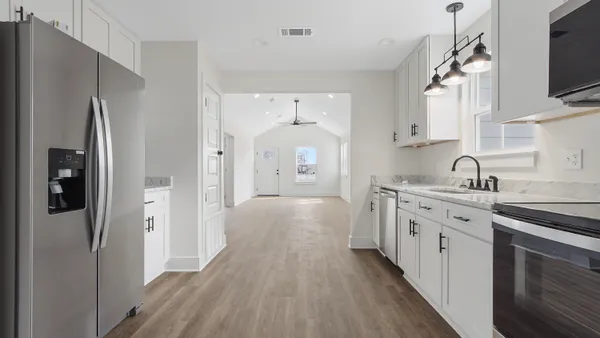 a view of a kitchen with a sink a refrigerator and cabinets