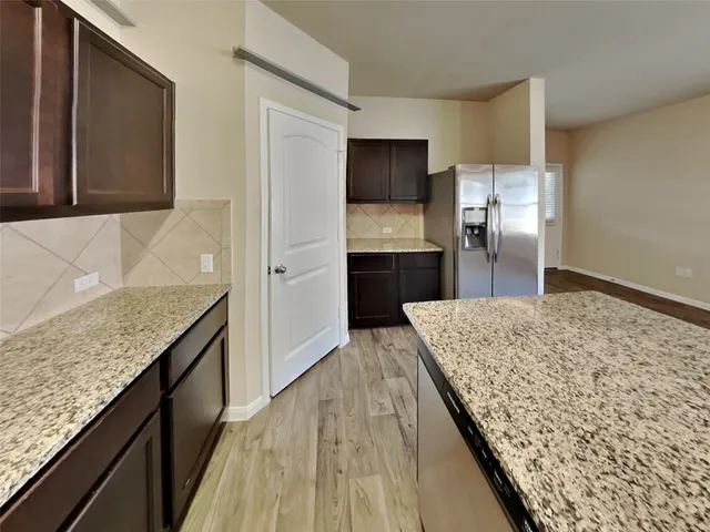 a view of kitchen with microwave a stove and wooden floor