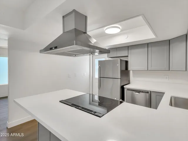 a kitchen with a sink a refrigerator and cabinets
