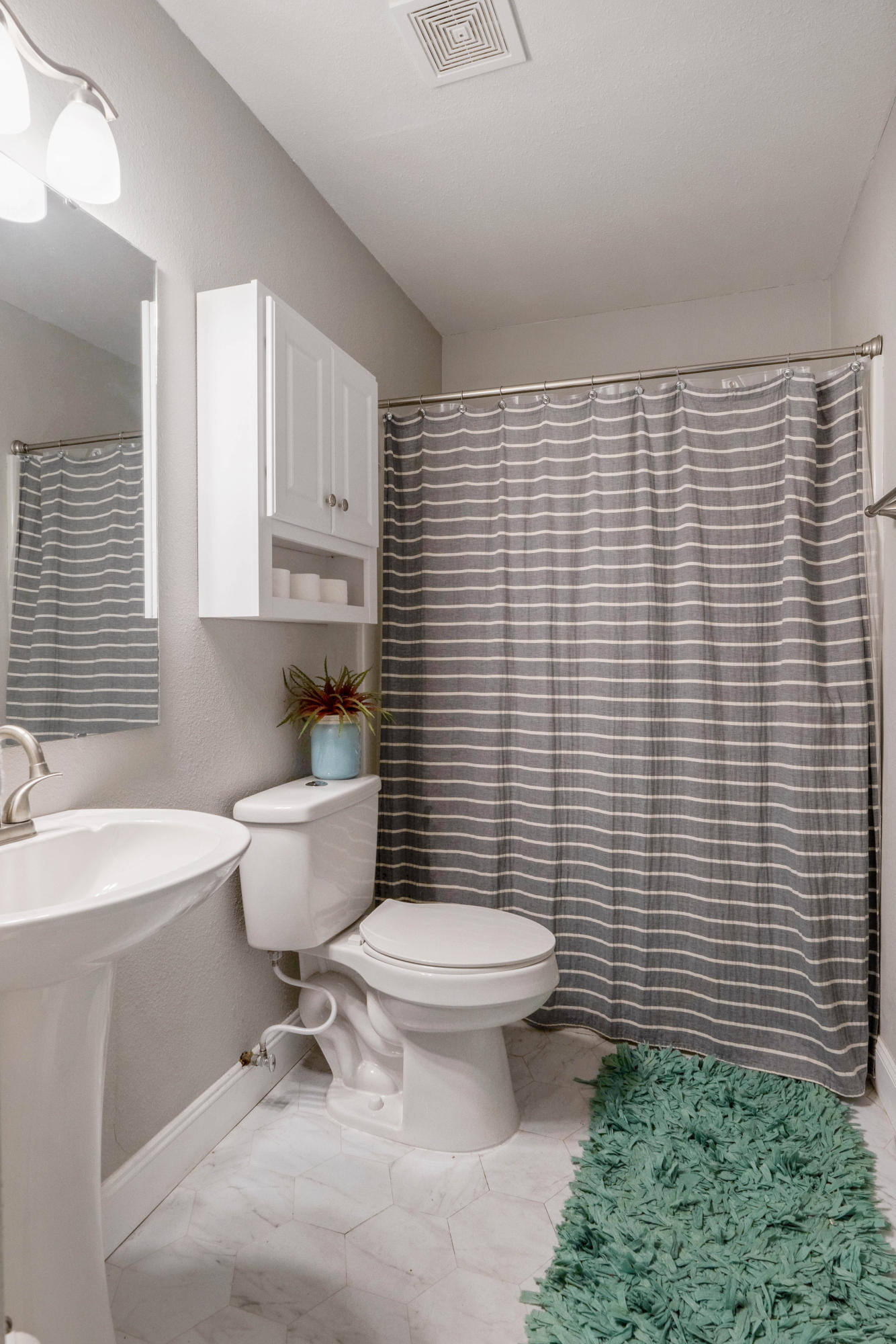 6086 Robin Road Crestview, FL 32539 - Photo 15 of 30 a bathroom with a toilet a sink a mirror and a shower