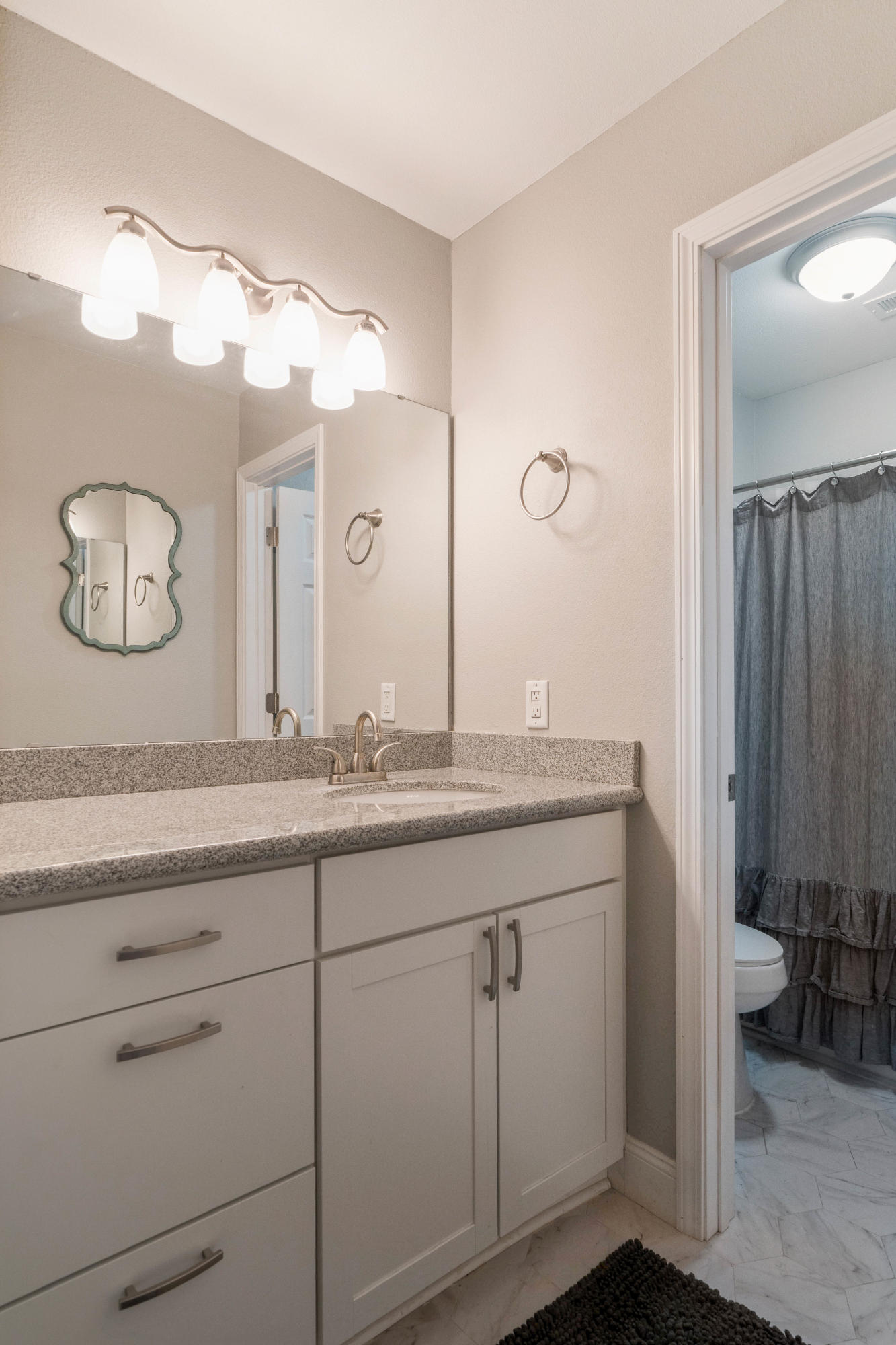 6086 Robin Road Crestview, FL 32539 - Photo 22 of 30 a bathroom with a granite countertop sink and a mirror
